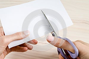 Female hands cutting paper with scissors