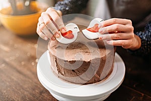 Female hands decorate cake with cookies