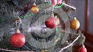 Female Hands Decorate Christmas Tree with New Year Christmas Decorations. Zoom