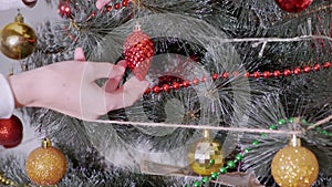 Female Hands Decorate Christmas Tree with New Year Christmas Decorations. Zoom