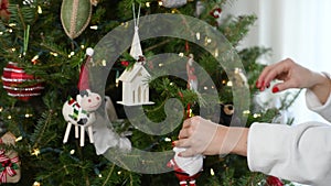 Female hands decorating Christmas tree in Slow Motion. Preparing for winter holidays