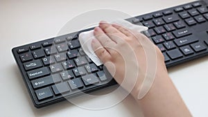 Female hands disinfect a computer keyboard