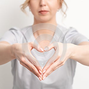 Female hands of doctor making heart shape