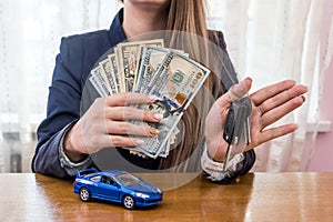 Female hands with dollars, car and keys