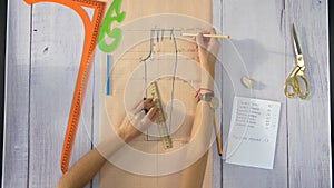 Female hands draw a line using a ruler, a pencil and paper