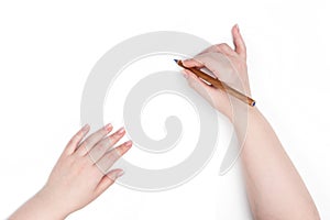 Female hands draws with a pencil on a white background. File contains a path to isolation.