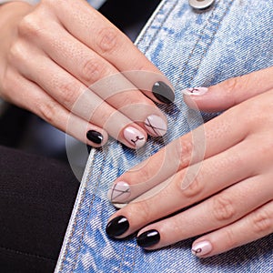 Female hands with fashion manicure nails, nude and black gel polish