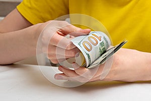 Female hands flipping a pack of dollars on a light stand, the concept of financial independence