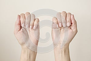 female hands with folded fingers showing nails