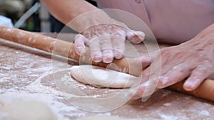 Female hands form pieces of dough for baking bread and rolls.