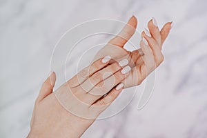 Female hands with french manicure on nails. Soft skin, skincare, beauty