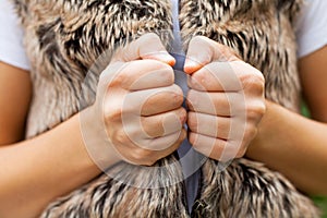 Female hands & fur vest