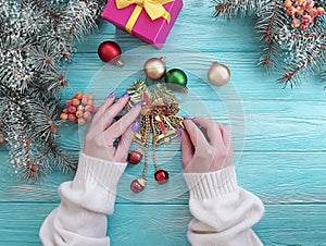 Female hands gift box, ball, table border holiday present decoration seasons Christmas tree branch on a wooden background