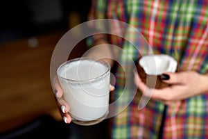 Female hands with glasse of vegan coconut milk