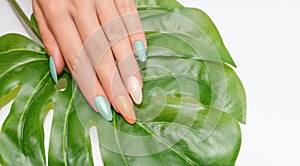 Female hands with glitter nail polish. Green and orange nail design with two shades. Women hands with sparkle colored manicure