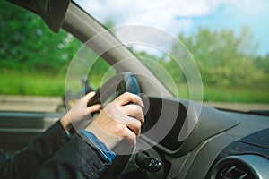 Female hands gripping car steering wheel