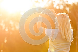 Female hands heart shape on nature green bokeh sun light flare and blur leaf abstract background. Happy love and freedom