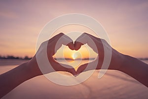 Female hands heart shape on sunset sky at tropical beach abstract background. Copy space of happy love travel and freedom in