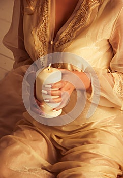 Female hands hold a burning candle. Beautiful woman holding candle. Romantic concept. Erotic concept.