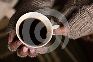 Female hands hold a coffee cup