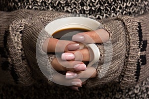 Female hands hold a coffee cup