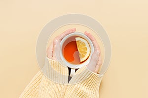 Female hands hold cup of tea with lemon