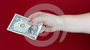 Female hands hold dollars, US currency banknotes on red background, counting a bundle of money, concept of cash, payments, savings