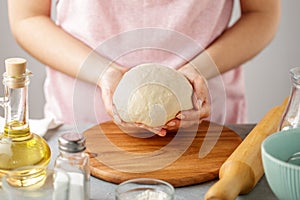 Female hands hold the dough for making tortillas.