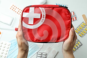 Female hands hold first aid medical kit on white background