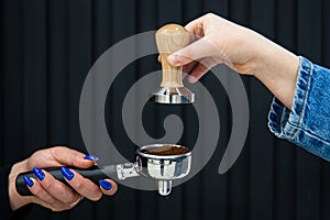 Female hands hold a holder with coffee and temperature on a black background.