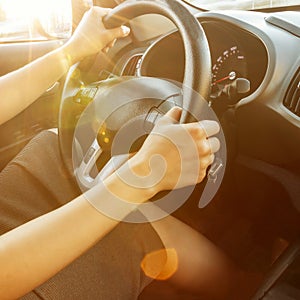 Female hands hold the steering wheel, close-up. A woman is driving a car.