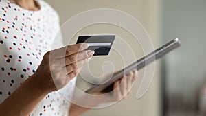 Female hands hold tablet credit card making purchase in internet