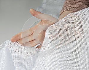 Female hands hold a transparent curtain.  texture of white tulle