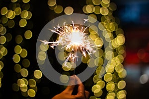 Female hands holding bengal light on black background. Christmas and newyear party sparkle