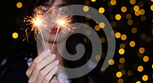 Female hands holding bengal light on black background. Christmas and newyear party sparkle