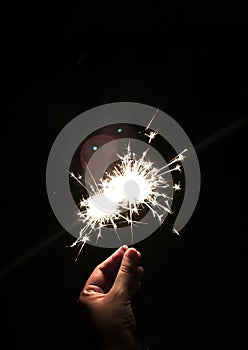 Female hands holding bengal light on black background. Christmas and newyear party sparkle