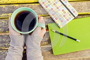 Female hands holding chamomile tea in a cup