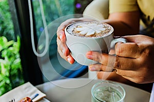 Female hands holding cups of coffee