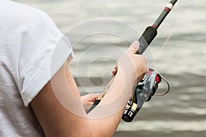 Female hands holding a fishing rod