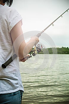 Female hands holding a fishing rod