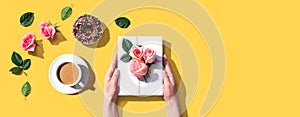 Female hands holding a gift box with pink roses