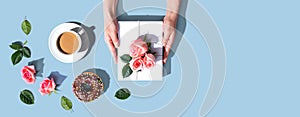 Female hands holding a gift box with pink roses