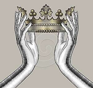 Female hands holding a gold crown