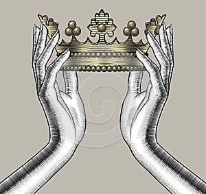 Female hands holding a gold crown photo