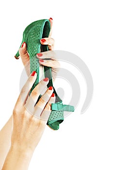 Female hands holding green sandals