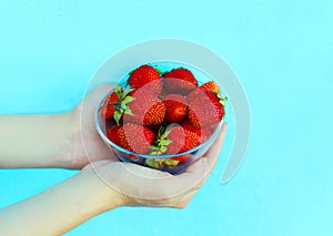 Female hands holding handful of strawberries close-up