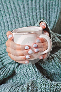 Female hands holding hot cup of coffee or tea