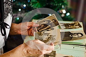 Female hands holding and old photo of her relatives. Vintage photo album. Genealogy and life values concept