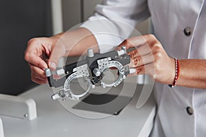 Female hands holding the optical device for eye testing