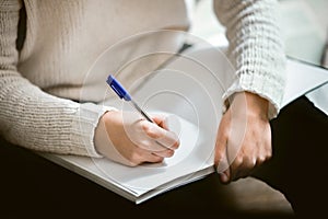 Female hands holding a pen and notebook